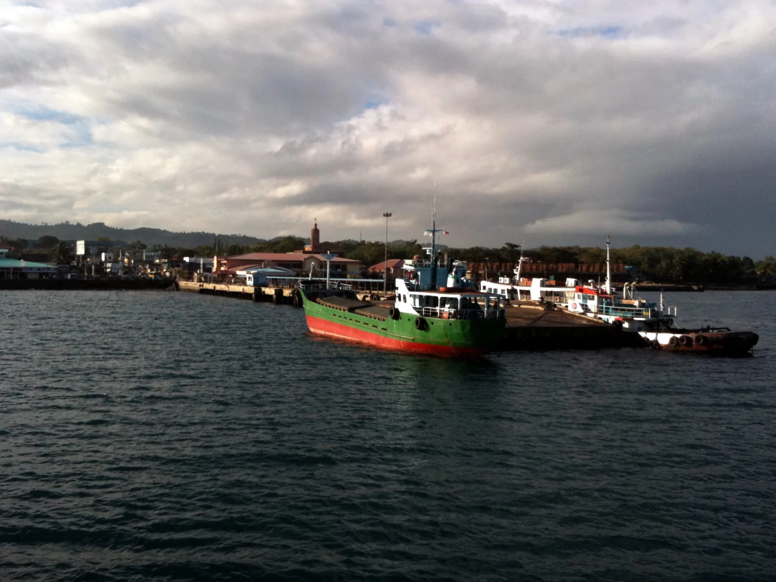 Boats moored at the Toledo pier under a cloudy sky.